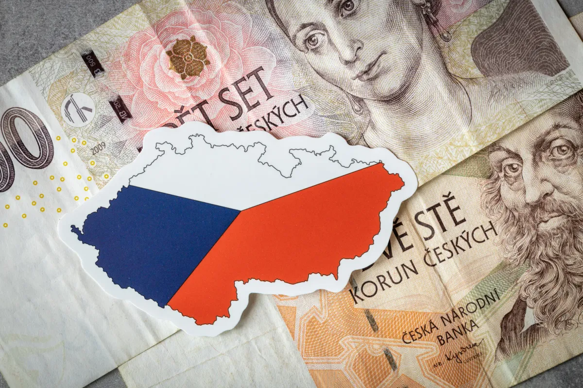 Small map of Czechia and some Czech krone bills in the background